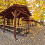 Piknikuplats Tartu lähedal Eesti Põllumajandusmuuseumis Ülenurmes, avar muruala piknikulaudade ja rohelise loodusega.